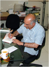 هوشنگ مرادي كرماني در حال امضاي كتابهاي مشتركين جيره كتاب